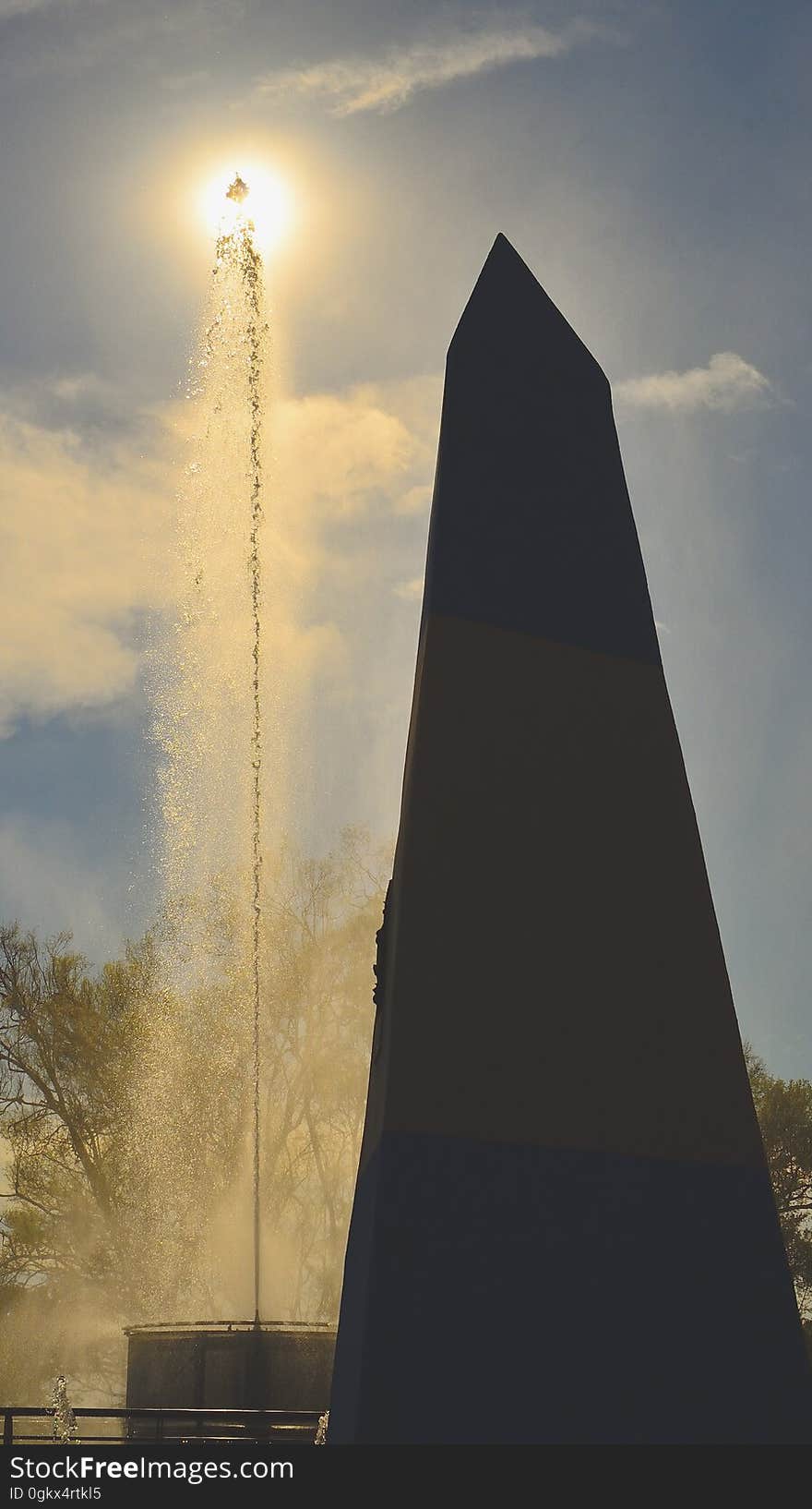 Black Tower Near Fountain Under Blue Sky and White Clouds