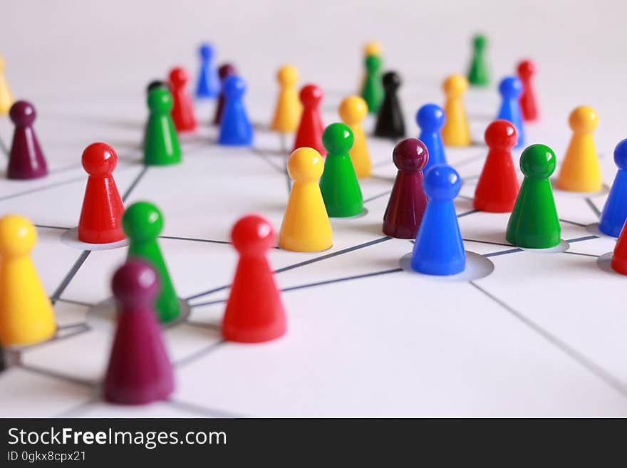 Close Up Photography of Yellow Green Red and Brown Plastic Cones on White Lined Surface