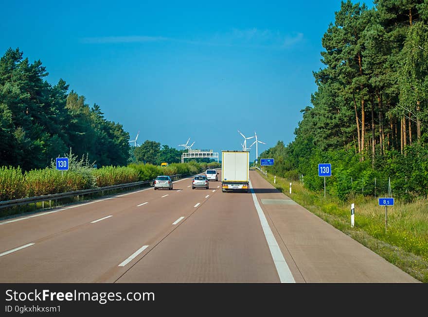 Vehicle Driving on Freeway Towards Wind Turbines