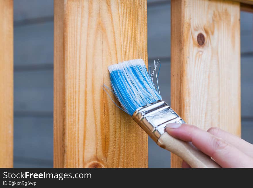 A person staining wooden planks.