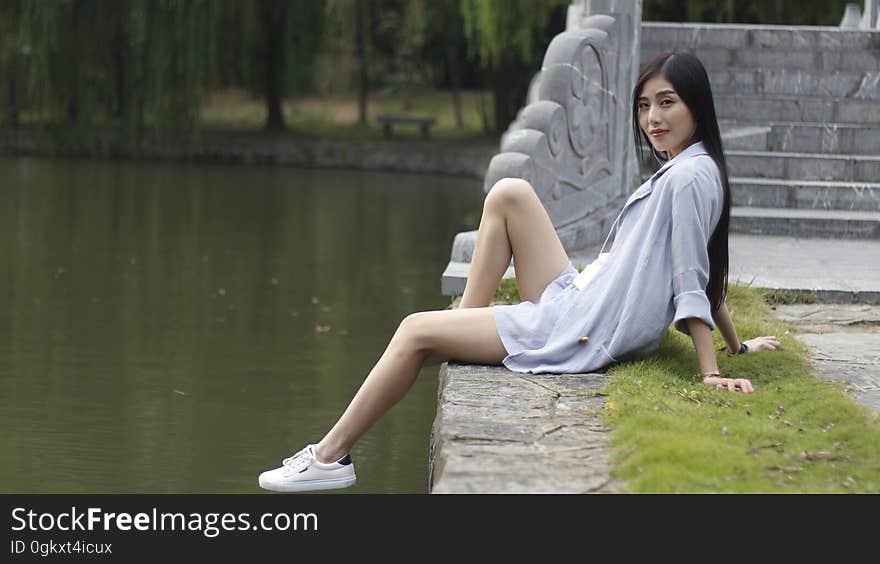 Woman Sitting beside a Lake