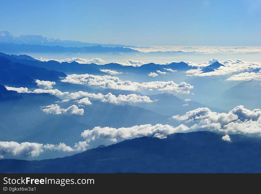 Scenic View of Clouds over Mountains Against Blue Sky