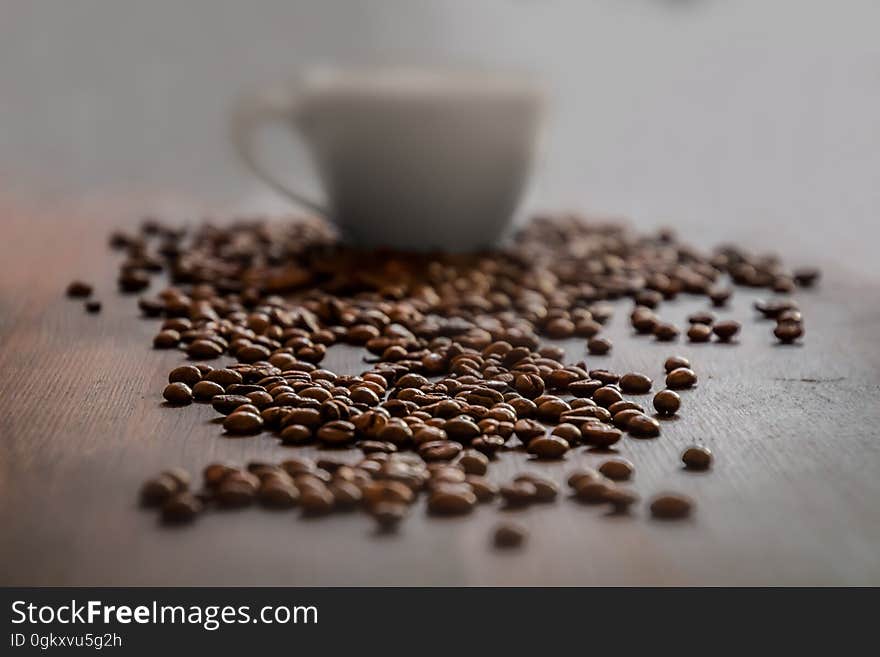 Background of coffee beans in front of a coffee cup. Background of coffee beans in front of a coffee cup.