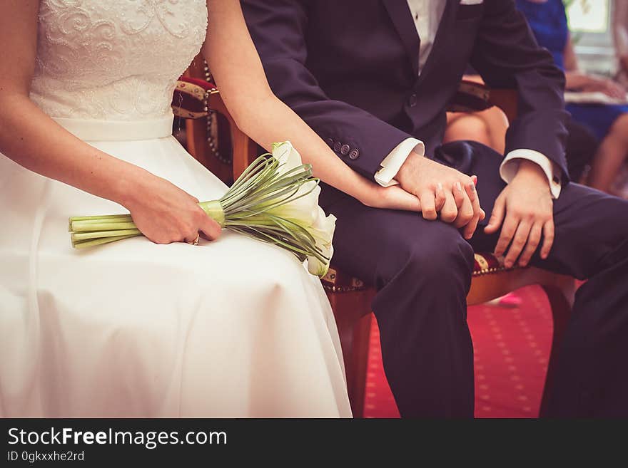 A bride and groom hold hands on their wedding day. A bride and groom hold hands on their wedding day.