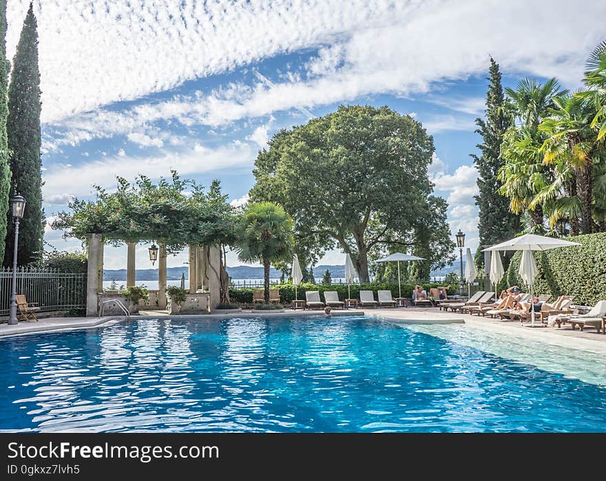 A seaside swimming pool with sunbeds and sunshades. A seaside swimming pool with sunbeds and sunshades.