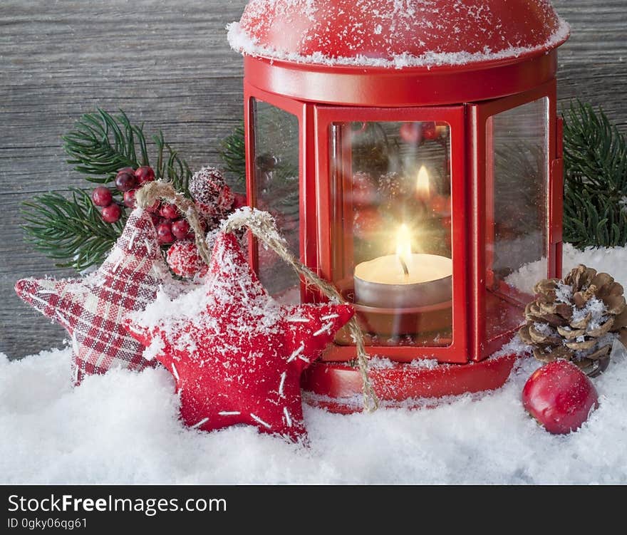 Christmas decorations around a red lantern with a tea light candle. Christmas decorations around a red lantern with a tea light candle.