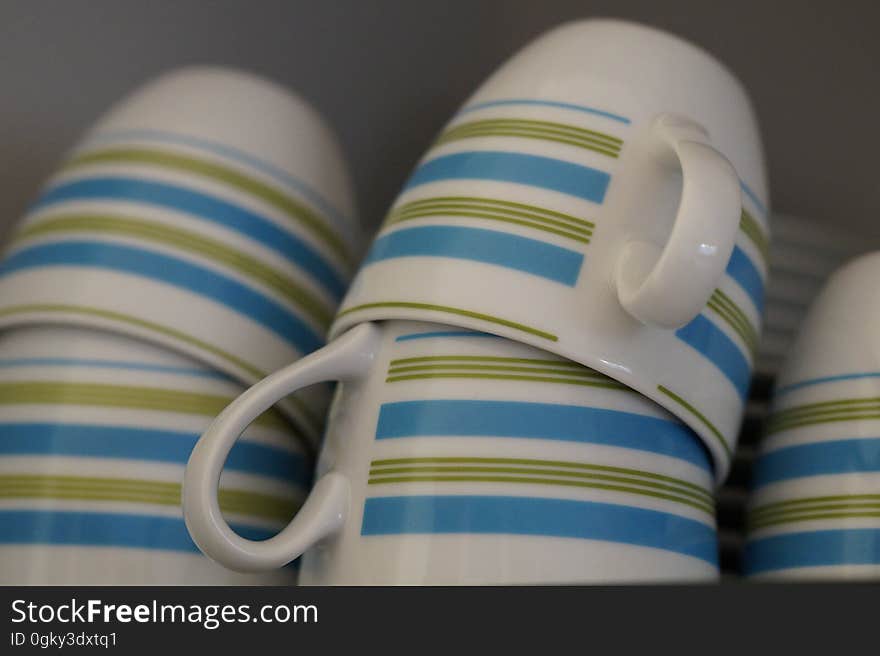 Striped mugs stacked on a shelf.