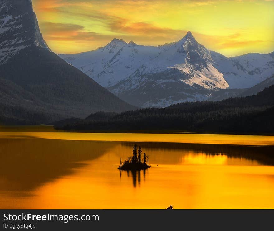 A beautiful Alaskan sunset framed by surrounding mountains is reflected onto a lake. A beautiful Alaskan sunset framed by surrounding mountains is reflected onto a lake.