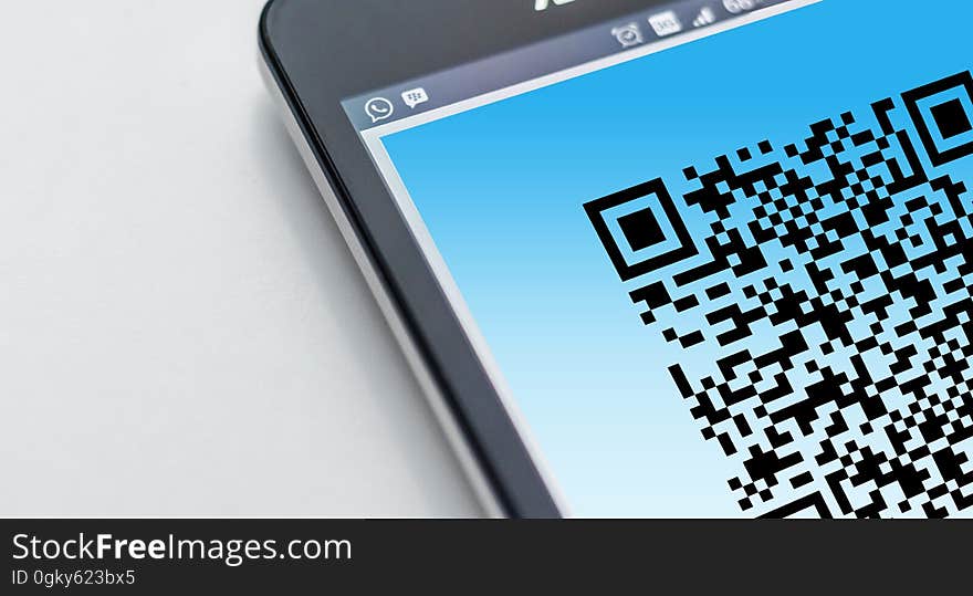 A smartphone with a QR code on the display. A smartphone with a QR code on the display.