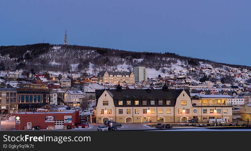 Houses in Norwegian town at dusk with snowy mountains in background. Houses in Norwegian town at dusk with snowy mountains in background.