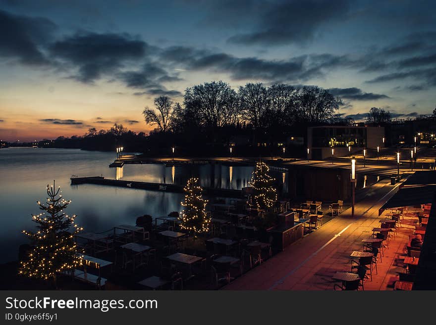 A night view of a lake with holiday lighting on the shore. A night view of a lake with holiday lighting on the shore.