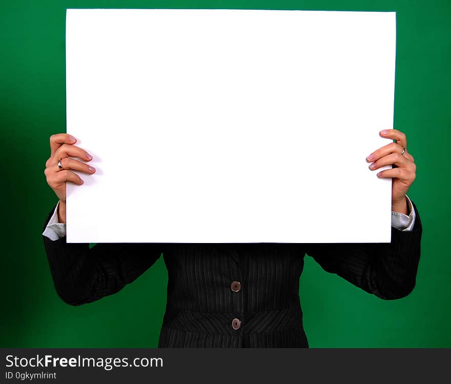 Person in a Black Coat Holding White Rectangular Board