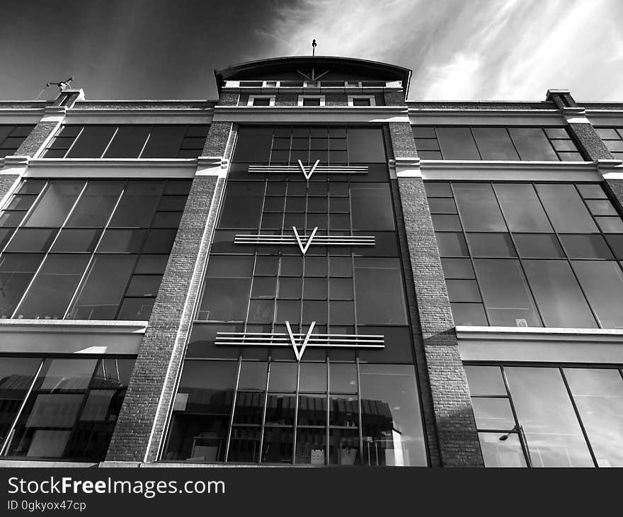 A monochrome photo of a modern office building from a low angle.