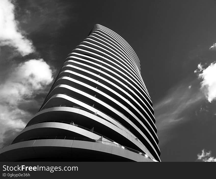 A black and white photo of a skyscraper with an organic shape. A black and white photo of a skyscraper with an organic shape.