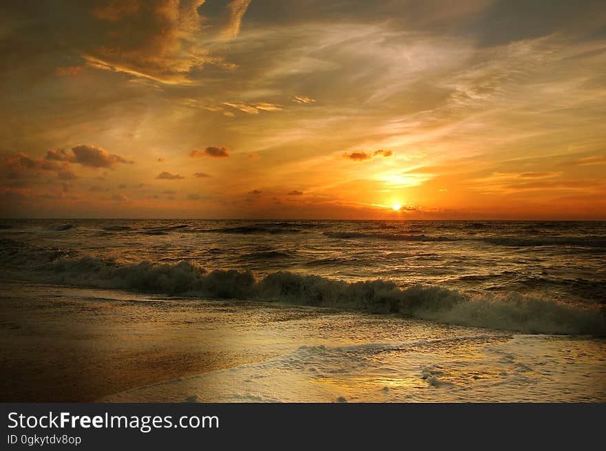 A sunset on a beach with colorful skies. A sunset on a beach with colorful skies.