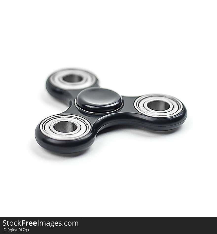 A close up of a metal fidget spinner on a white background.