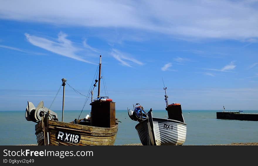 A pair of wooden fishing boats on a seacoast. A pair of wooden fishing boats on a seacoast.