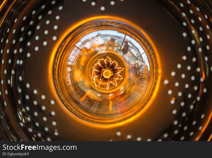 Close up of glass bulb in orange light fixture. Close up of glass bulb in orange light fixture.