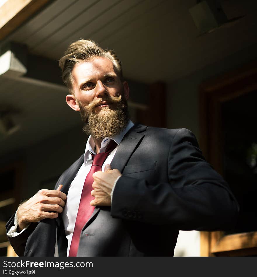 A confident businessman adjusting his suit jacket.