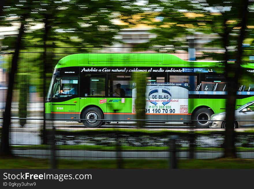 A green city bus on the street. A green city bus on the street.