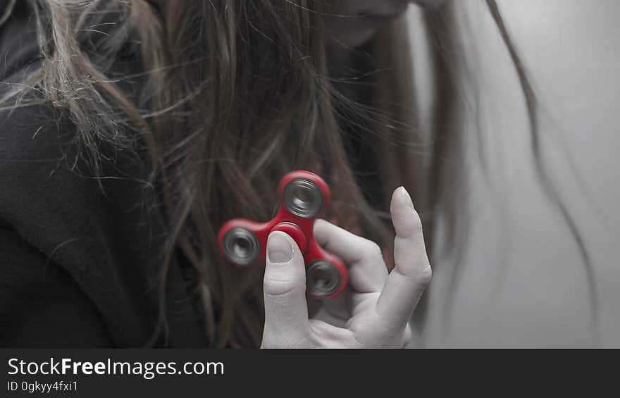 A girl holding up a fidget spinner. A girl holding up a fidget spinner.