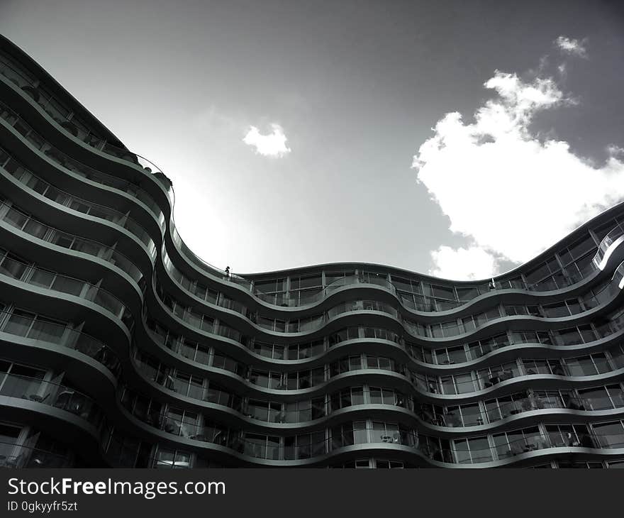 Contemporary roof line of modern architecture against cloudy skies in black and white. Contemporary roof line of modern architecture against cloudy skies in black and white.