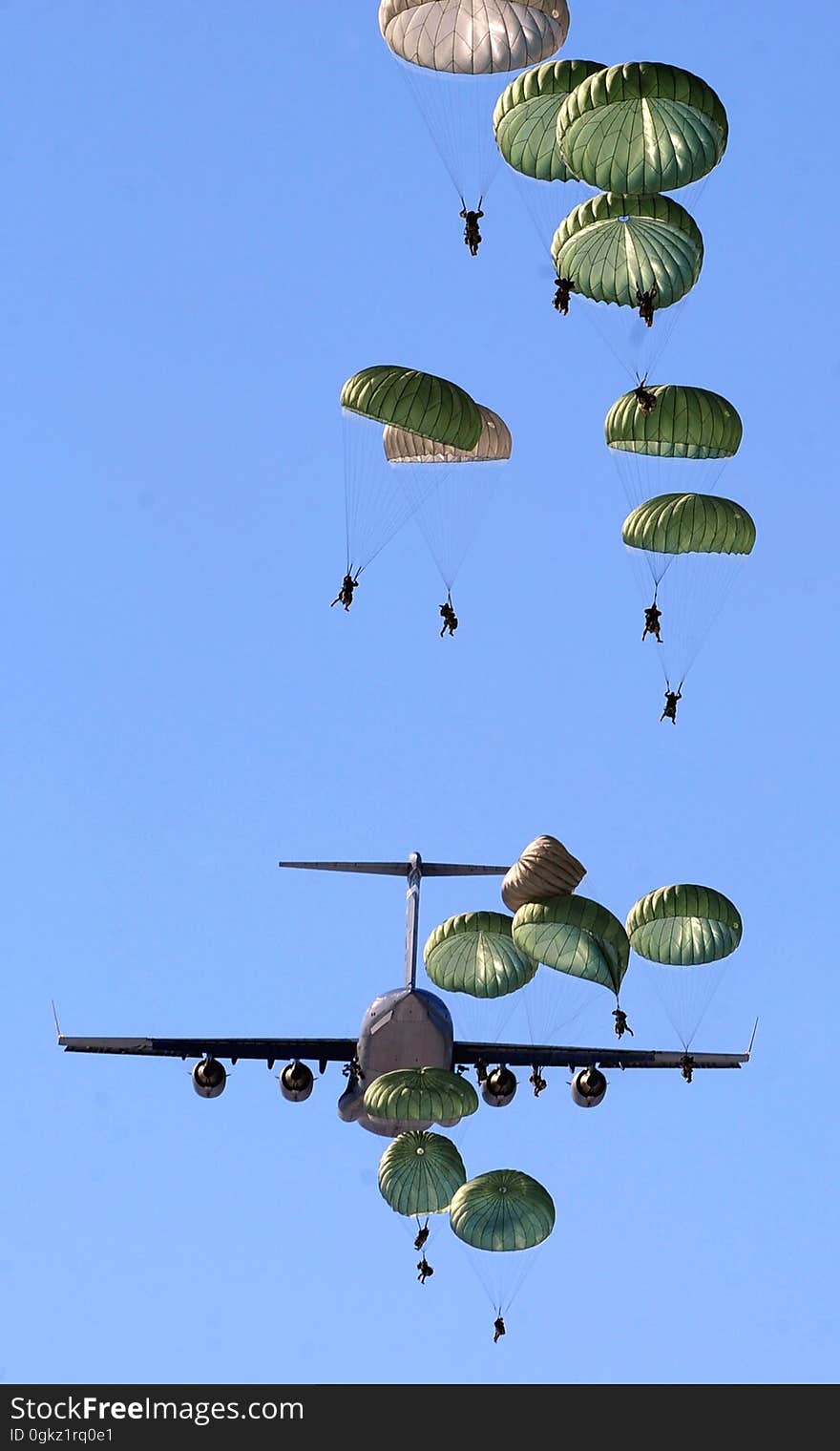 Army Paratroopers Practicing Parachute Drop from a Military Air Plane during Daytime