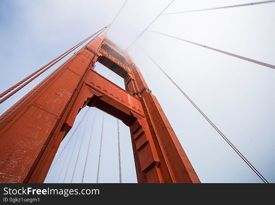 An angled view of a suspension bridge seen from the ground.