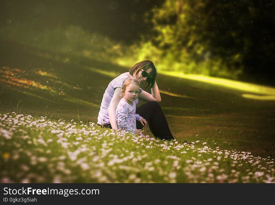 Portrait of mother with young daughter in field of wildflowers on sunny day. Portrait of mother with young daughter in field of wildflowers on sunny day.