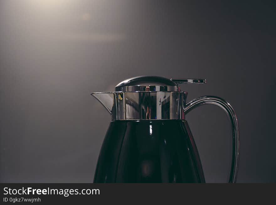 Close up of coffee carafe with metal handle.