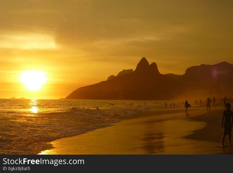 Group of People on Seashore during Sunset