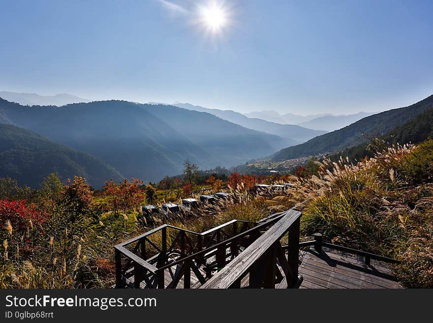 Wooden stairway with deck through fields in alpine landscape on sunny day. Wooden stairway with deck through fields in alpine landscape on sunny day.