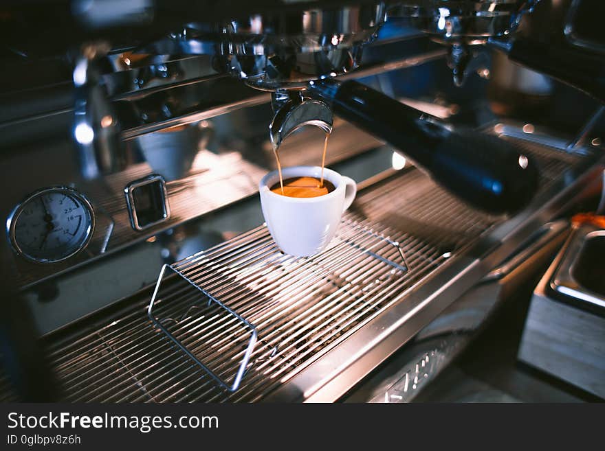 Close up of cup of espresso brewed by machine inside cafe. Close up of cup of espresso brewed by machine inside cafe.