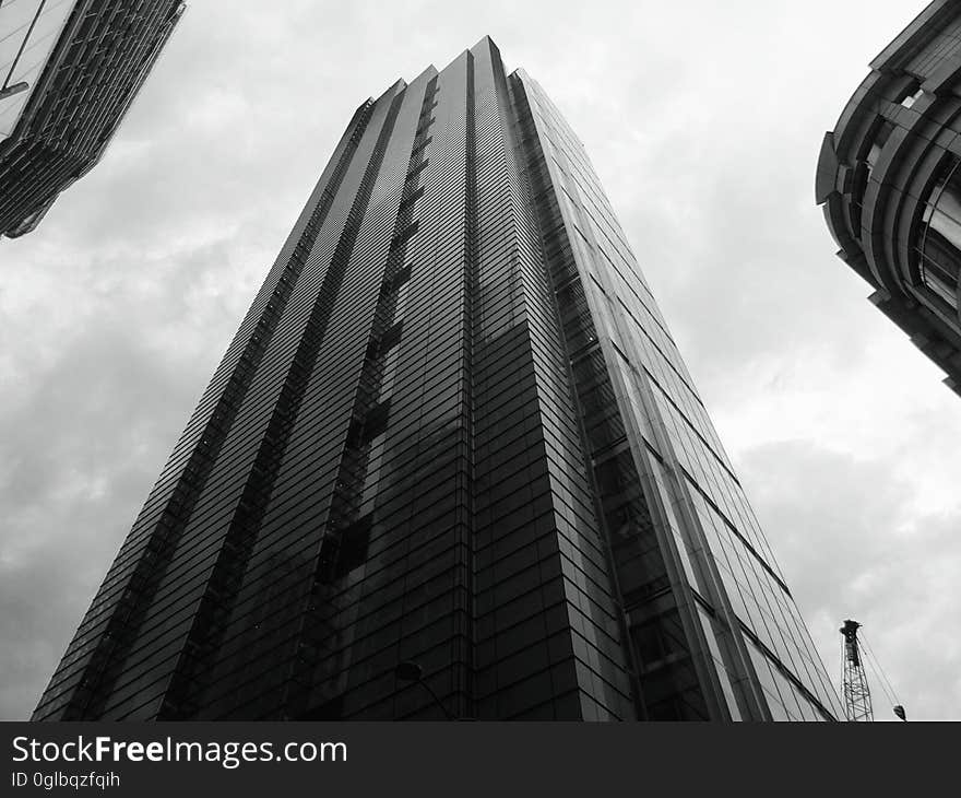 High rise contemporary buildings against cloudy skies in black and white. High rise contemporary buildings against cloudy skies in black and white.