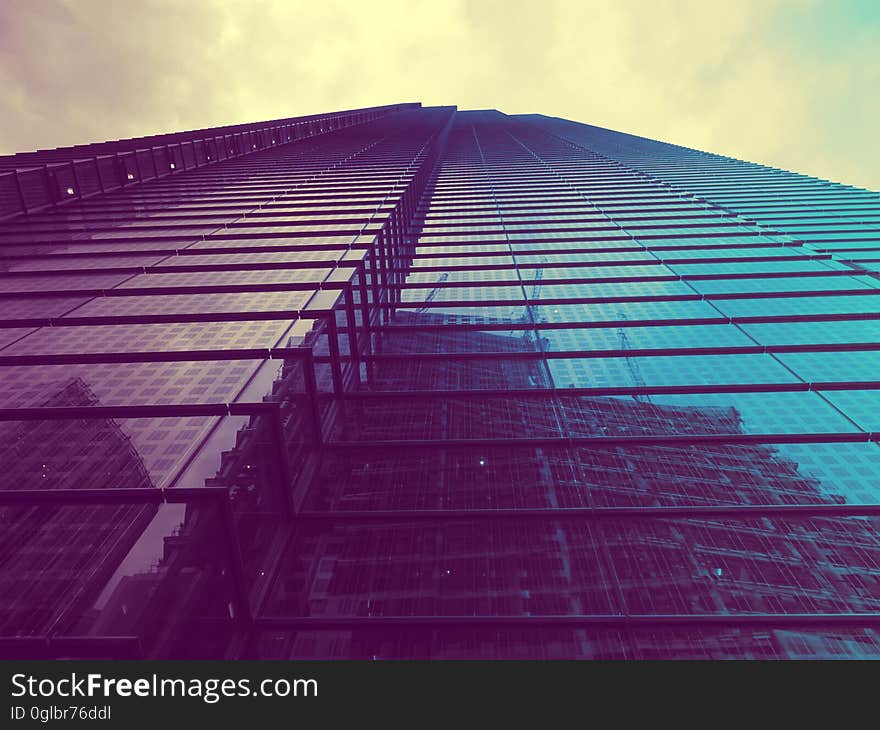 Architectural reflections in facade of high rise building against overcast skies. Architectural reflections in facade of high rise building against overcast skies.