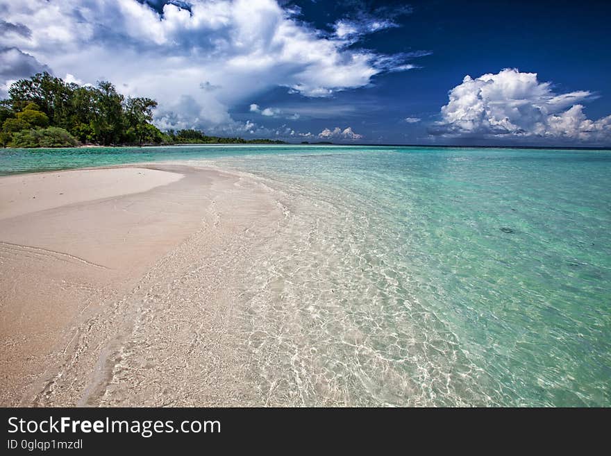 Sandy beach on coastline against blue skies on sunny day. Sandy beach on coastline against blue skies on sunny day.