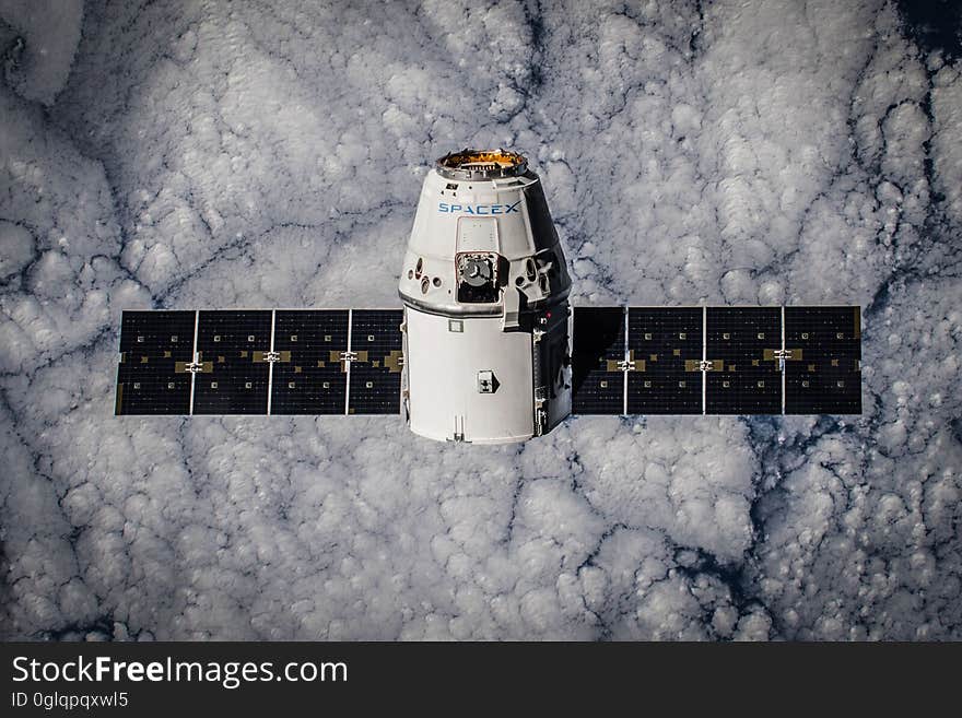 Spacex satellite in orbit over clouds. Spacex satellite in orbit over clouds.