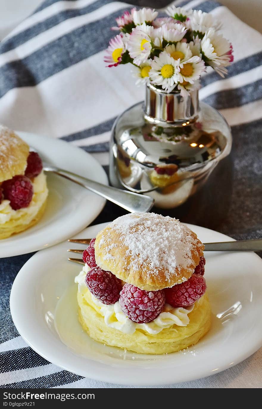 Cream puff with raspberries on table.