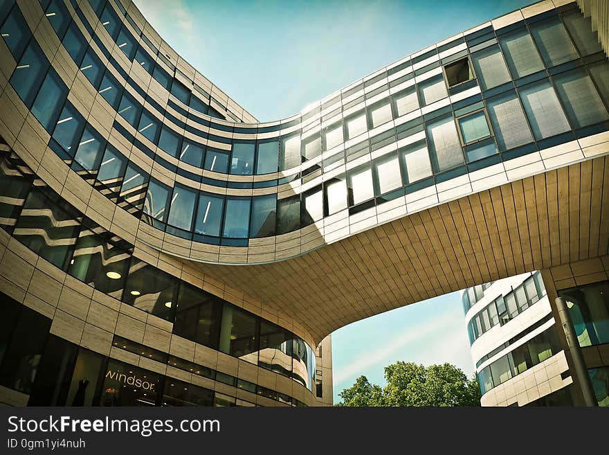 Worm&#x27;s Eye View of Brown and Black Building Bridge Under Blue and White Cloudy Sky