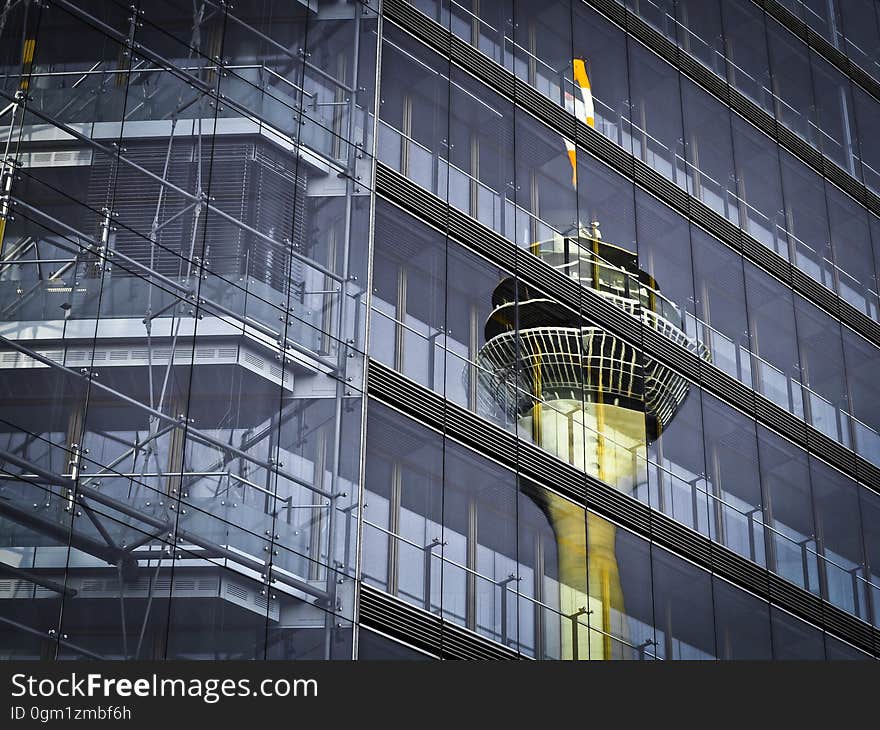 A tower reflecting on a glass building facade. A tower reflecting on a glass building facade.