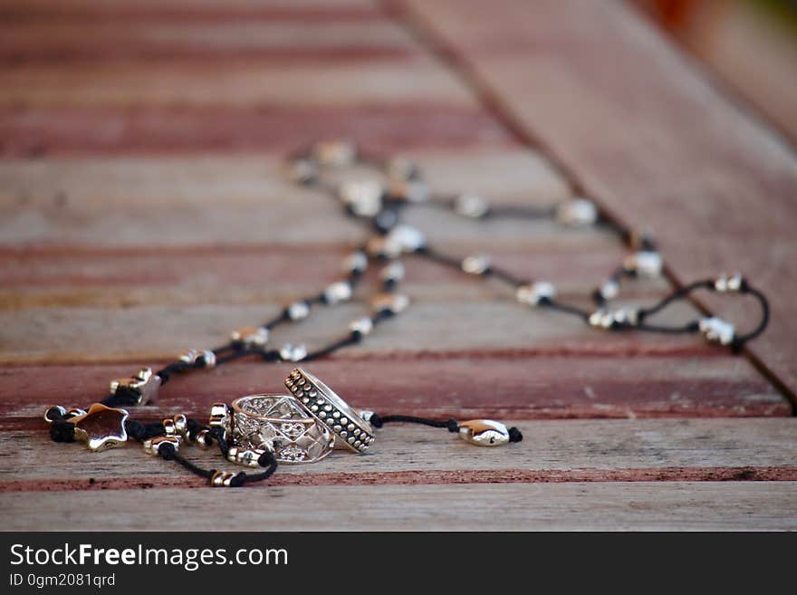 A necklace with silver trimmings on wooden background. A necklace with silver trimmings on wooden background.