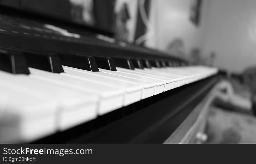 Close up of acoustic piano keys in black and white inside home.