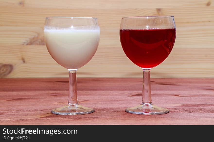 Glasses with wine and milk on a wooden table