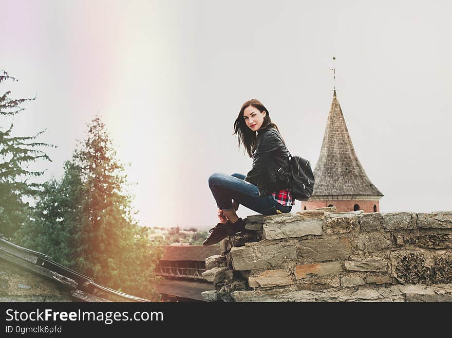 Young woman sitting outdoors looking at camera. Copy space