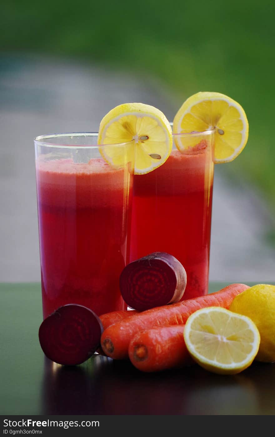 Glasses of multivitamin juice with decorative lemon slices.