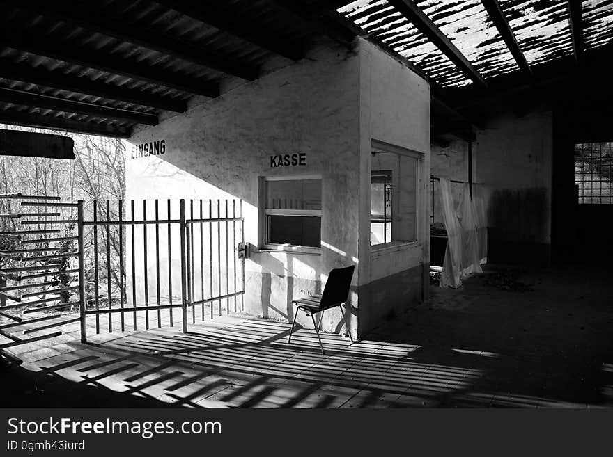 A chair by a gate in an old abandoned house. A chair by a gate in an old abandoned house.