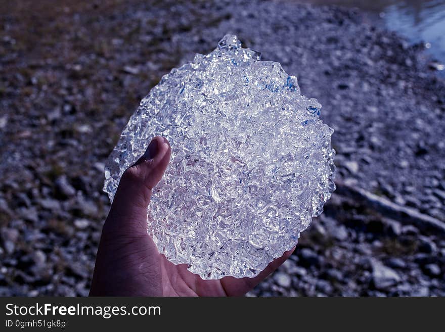 Hand of person outdoors holding lump of frozen ice crystals. Hand of person outdoors holding lump of frozen ice crystals.