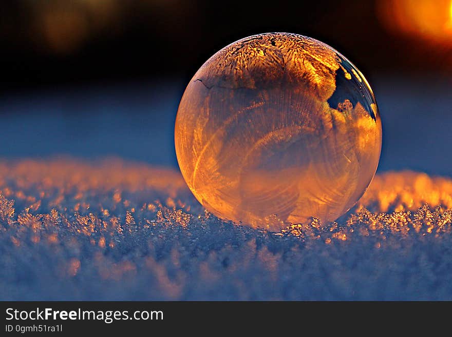 Orange illuminated transparent ball reflecting white frost. Orange illuminated transparent ball reflecting white frost.