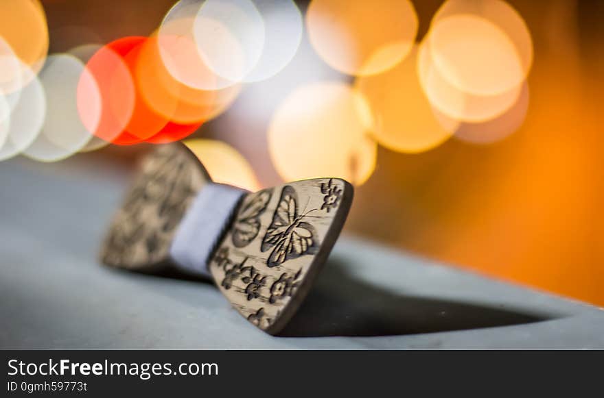 Closeup of wooden carved bow with butterfly shapes, bokeh lights in background. Closeup of wooden carved bow with butterfly shapes, bokeh lights in background.