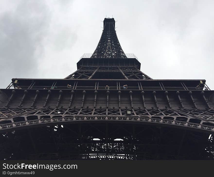 Underneath the Eiffel Tower in Paris, France with overcast skies. Underneath the Eiffel Tower in Paris, France with overcast skies.